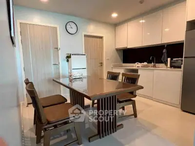 Modern kitchen with sleek cabinets and dining area in contemporary apartment