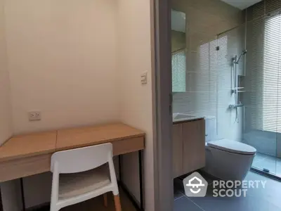 Modern bathroom with glass shower and adjacent study area