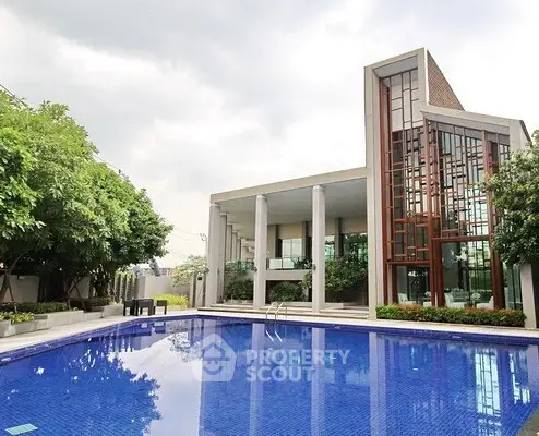 Luxurious modern building with a stunning outdoor pool and lush greenery, perfect for relaxation and leisure.