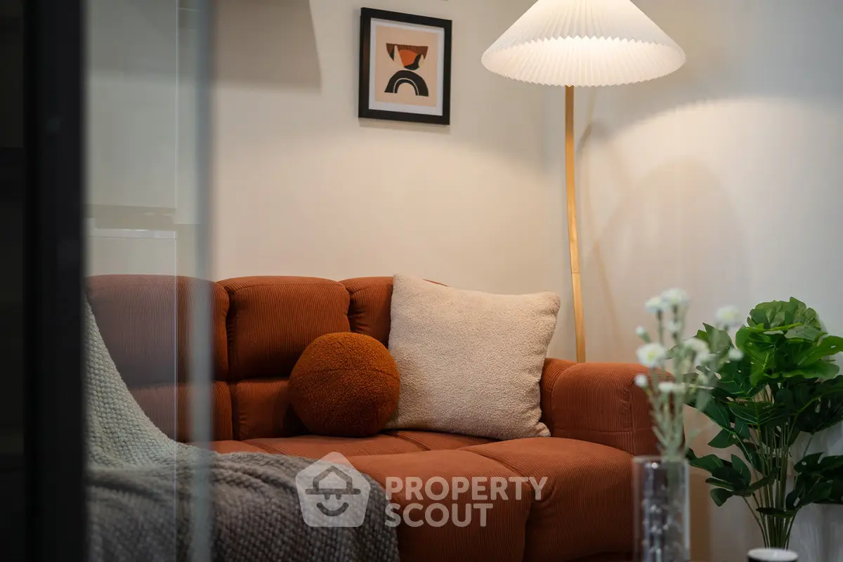 Cozy living room with stylish decor and warm lighting, featuring a plush sofa and modern floor lamp.