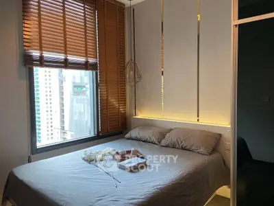 Cozy bedroom with city view, featuring modern decor and ambient lighting.