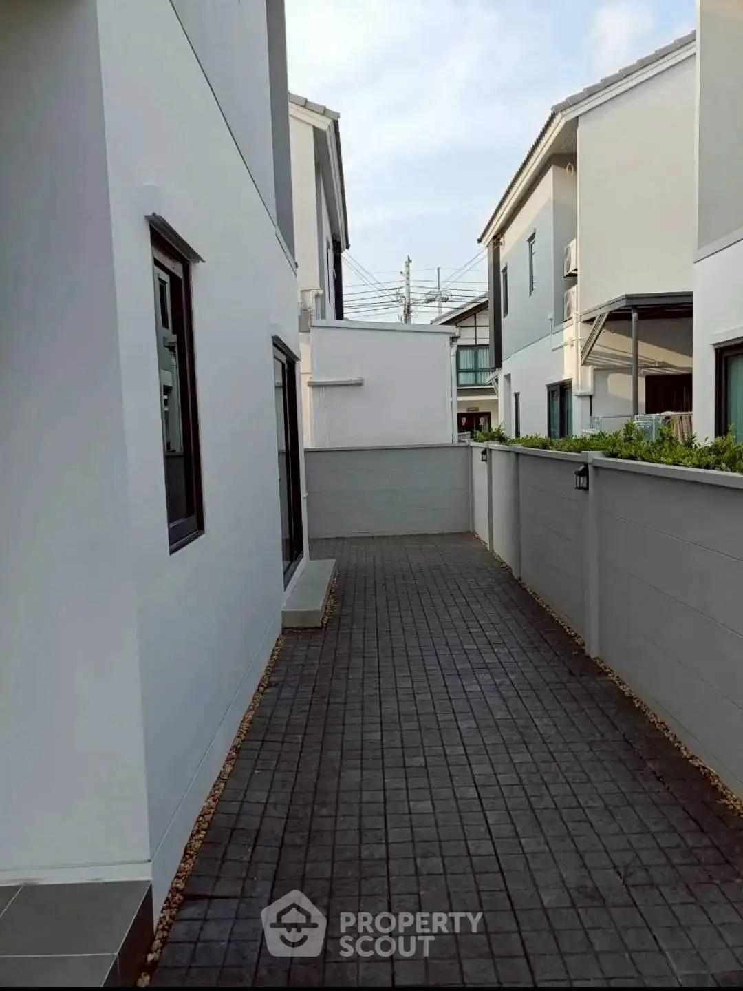 Modern townhouse exterior with clean lines and paved walkway, ideal for urban living.