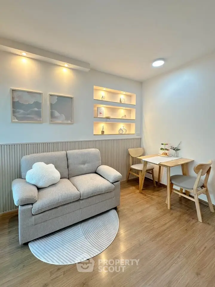 Cozy living room with modern decor and wooden flooring, featuring a stylish sofa and dining area.