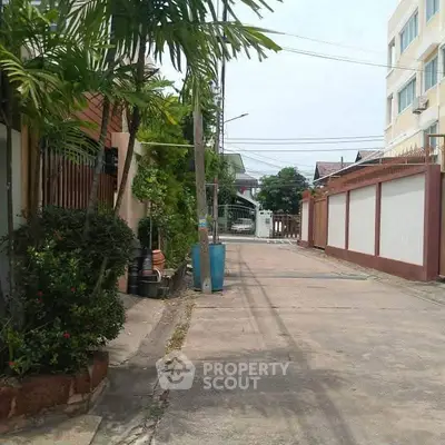 Charming residential street with lush greenery and modern architecture.