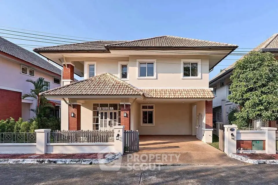 Charming two-story house with tiled roof and spacious driveway in a serene neighborhood.