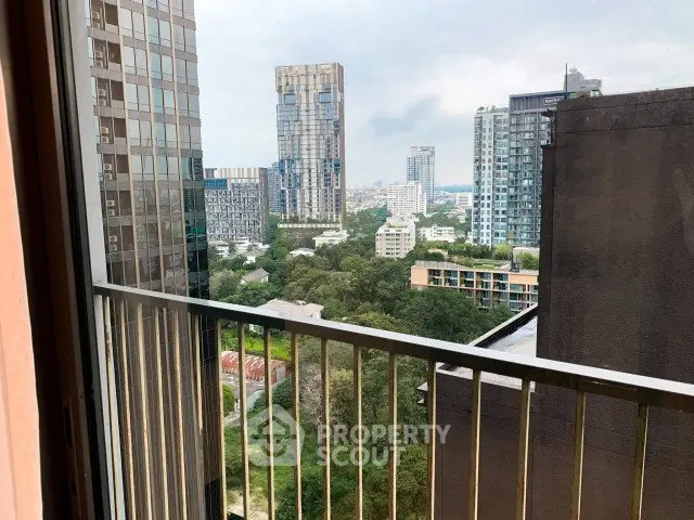 Stunning cityscape view from a high-rise balcony overlooking lush greenery and modern skyscrapers.