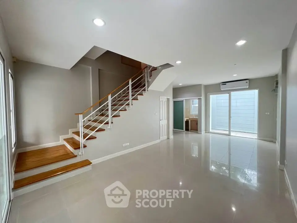Spacious modern living room with sleek staircase and large windows