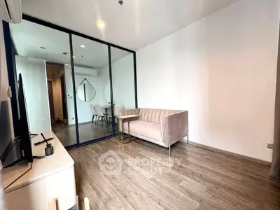 Modern living room with sleek glass partition and stylish furniture in a contemporary apartment.