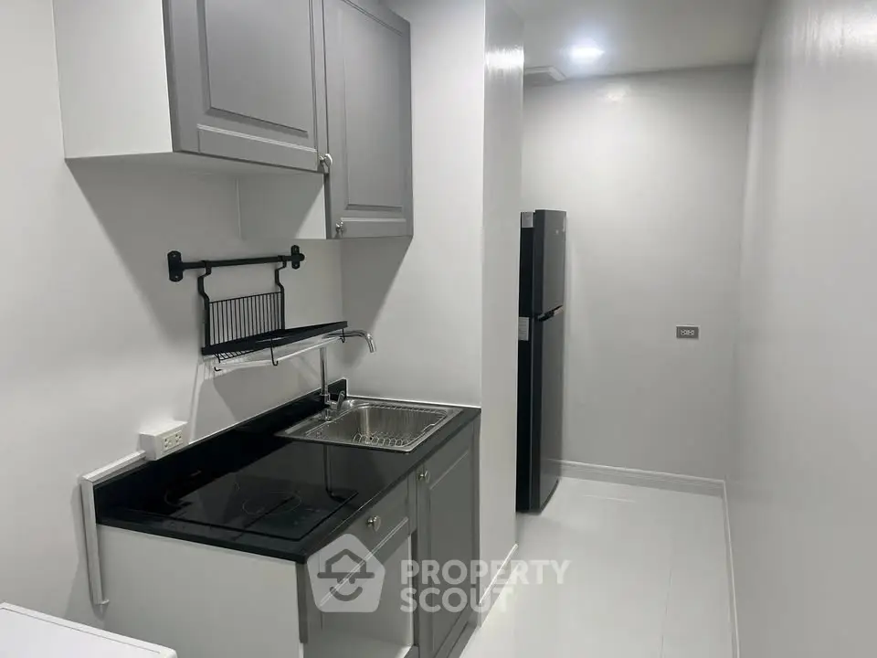 Modern compact kitchen with sleek cabinetry and built-in appliances in a minimalist design.