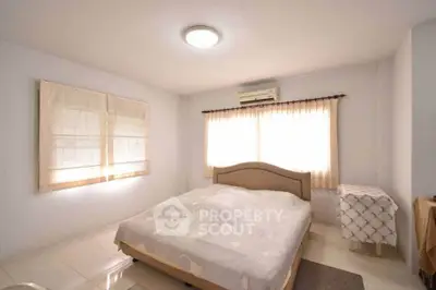 Bright and cozy bedroom with large windows and neutral decor