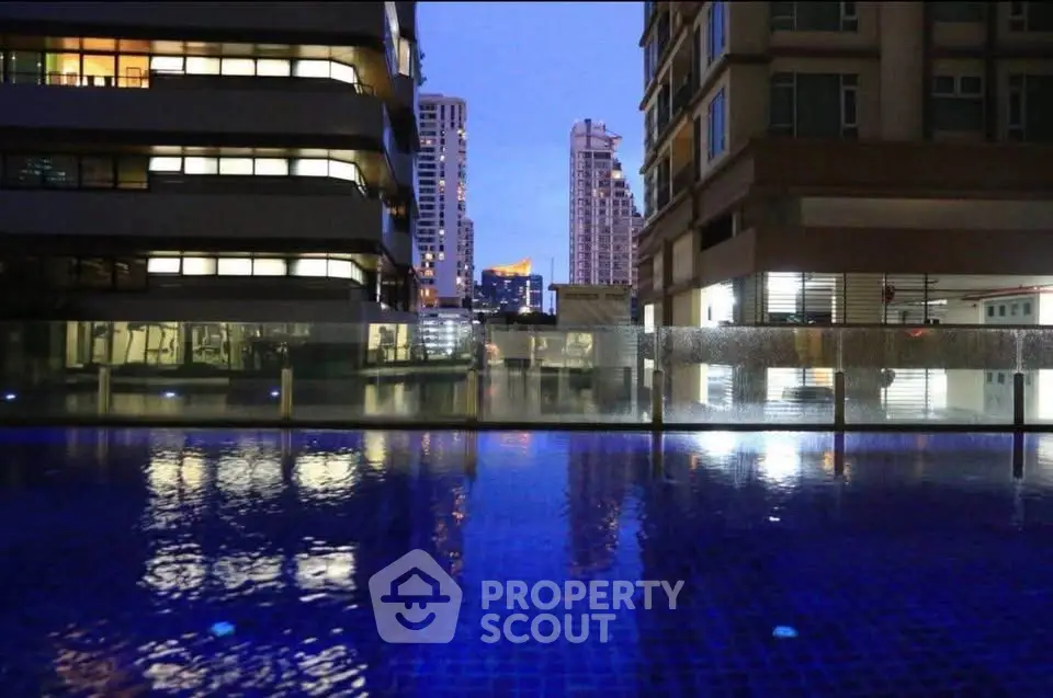Stunning urban pool view surrounded by modern high-rise buildings at dusk.