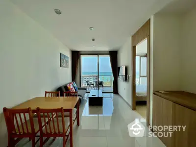 Modern living room with ocean view, sleek furniture, and natural light