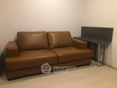 Cozy living room with brown leather sofa and modern side table