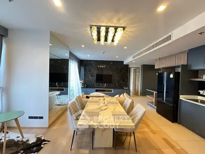 Luxurious modern dining area with marble table and elegant lighting in open-plan living space.