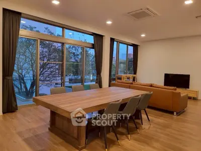 Spacious modern living room with large windows and elegant dining area