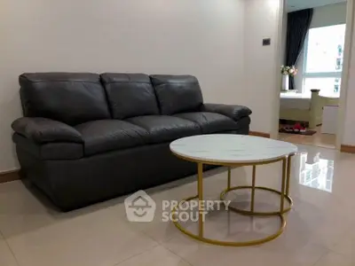 Modern living room with sleek leather sofa and stylish round coffee table.