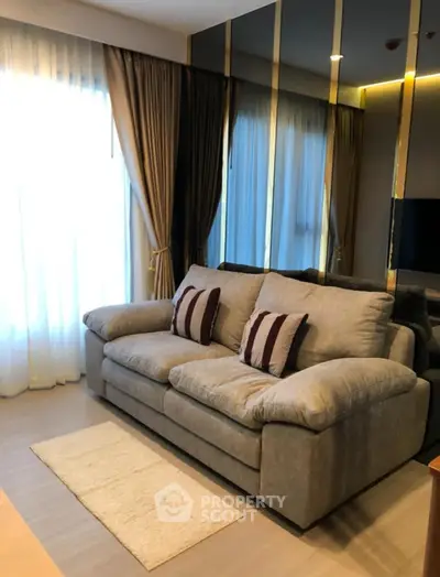 Elegant living room with plush sofa and floor-to-ceiling windows, perfect for relaxation.