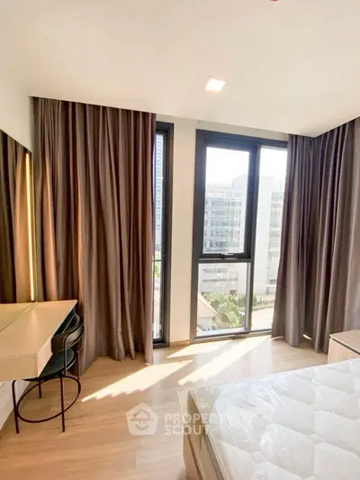 Bright bedroom with large windows and modern furnishings in urban apartment