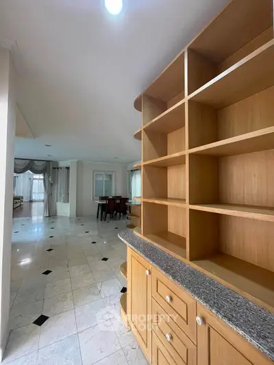 Spacious open-plan living area with elegant shelving and tiled flooring