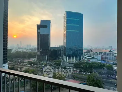 Stunning cityscape view from a high-rise balcony at sunset, showcasing modern skyscrapers and urban landscape.