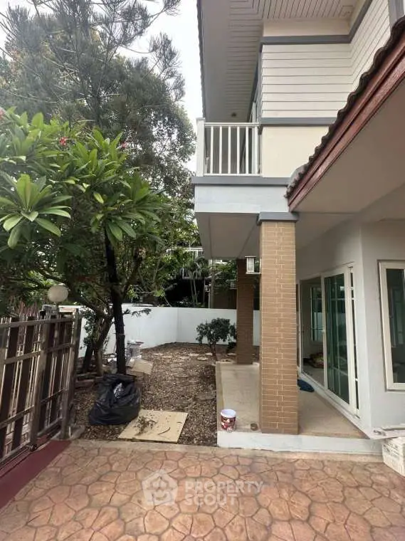 Charming two-story home with spacious garden and patio, perfect for outdoor living and relaxation.