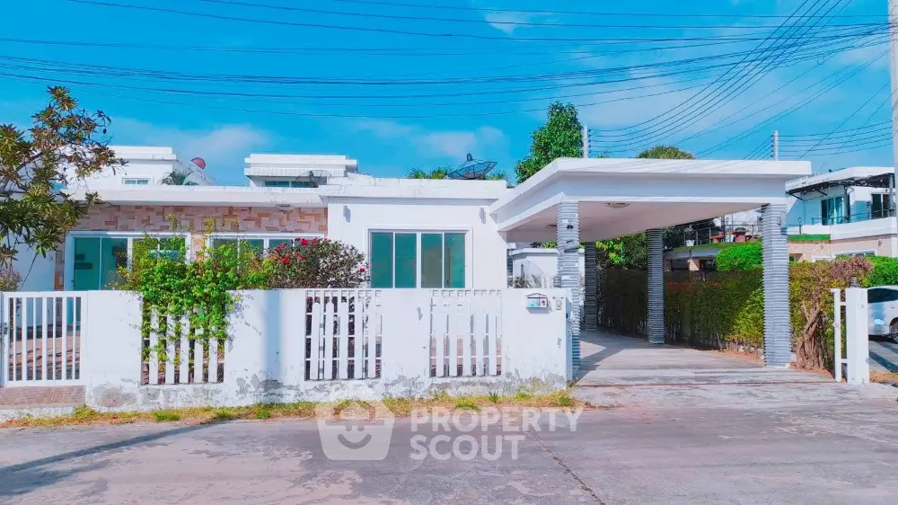 Charming single-story house with a spacious driveway and lush greenery, perfect for family living.
