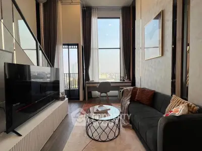 Modern living room with high ceilings, large windows, and stylish decor in a luxury apartment.