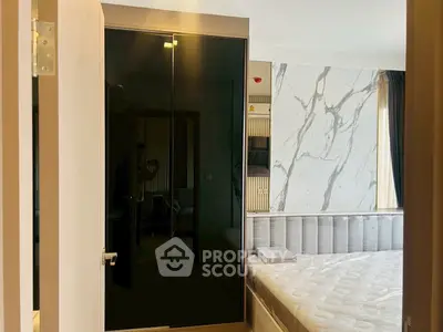 Modern bedroom with stylish marble accent wall and sleek wardrobe design.