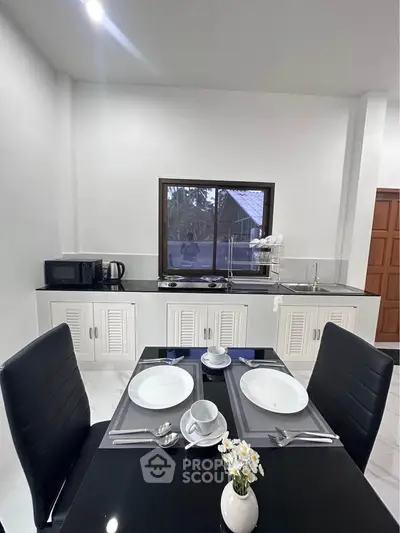 Modern kitchen with sleek black dining table and white cabinetry