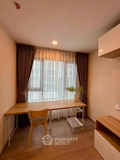 Modern study room with large window and elegant wooden desk in a stylish apartment.