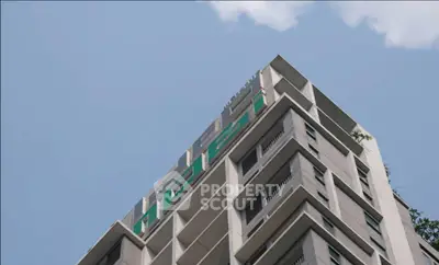 Modern high-rise building exterior with clear blue sky backdrop