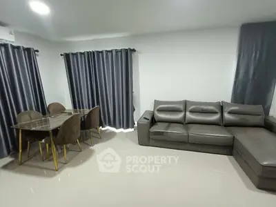 Modern living room with sleek leather sofa and elegant dining set.