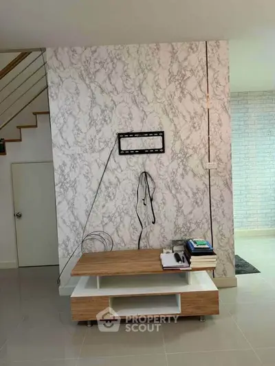 Modern living room with marble accent wall and wooden TV stand