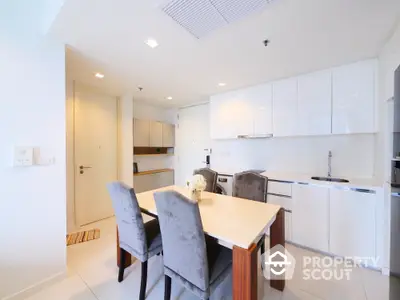 Modern kitchen with sleek white cabinets and elegant dining area