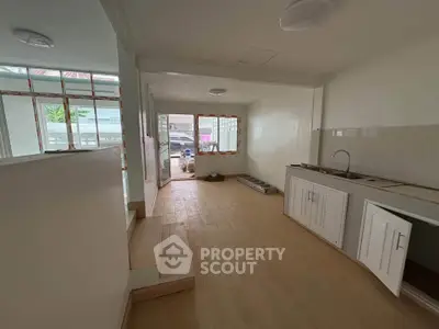 Spacious open-plan living area with modern kitchen and large windows for natural light.