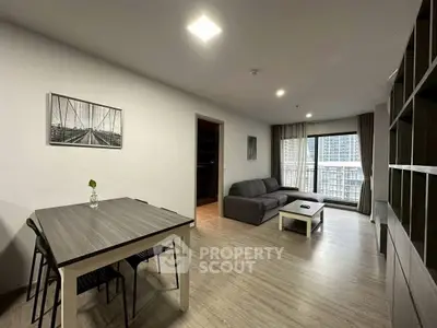 Spacious modern living room with stylish furniture and large windows offering city views.