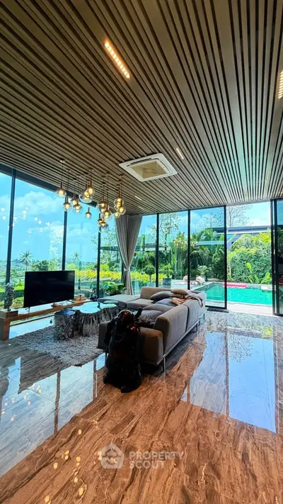 Luxurious living room with pool view, modern decor, and floor-to-ceiling windows.