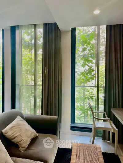 Modern living room with large windows and lush greenery view