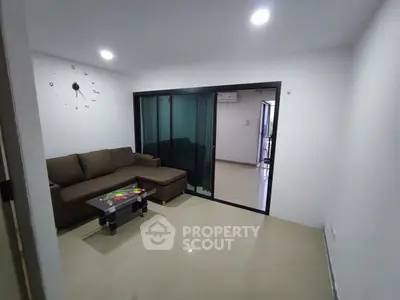 Modern living room with sleek glass partition and cozy brown sofa