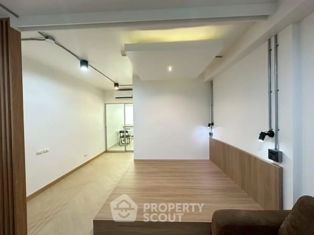 Modern minimalist living room with wooden flooring and recessed lighting