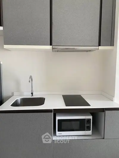 Modern kitchen with sleek cabinetry and built-in microwave