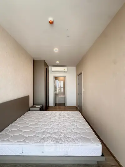 Spacious bedroom with modern design and ample natural light, featuring a comfortable mattress and sleek flooring.