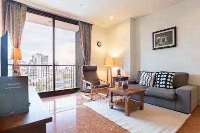 Spacious living room with city view, modern furniture, and large windows in a high-rise apartment.