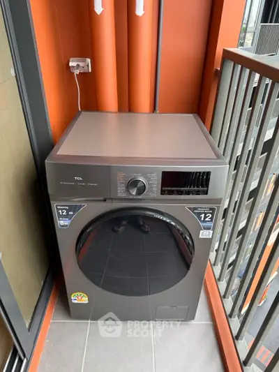 Modern washing machine on a stylish balcony with orange accents and sleek design.