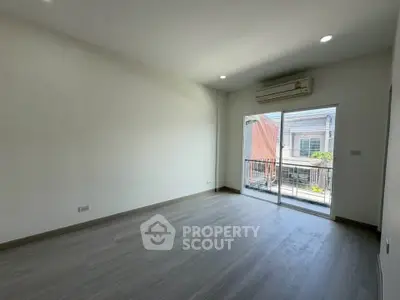 Spacious empty room with large window and balcony access, perfect for customization.