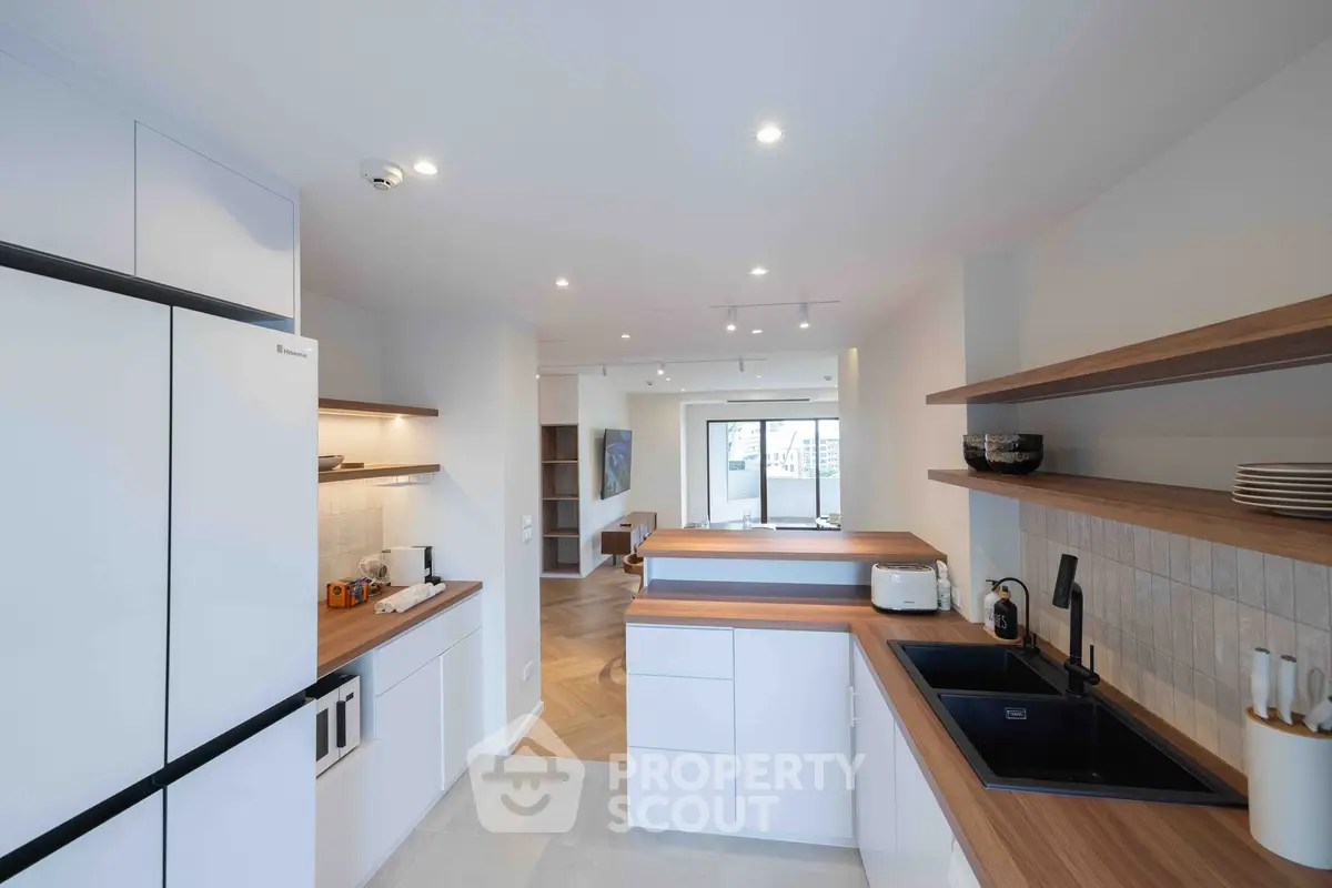 Modern kitchen with open layout and sleek wooden countertops