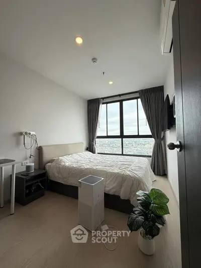 Modern bedroom with large window offering stunning city view, featuring cozy bed and air purifier.