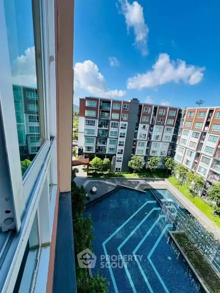 Modern apartment complex with pool view and clear blue sky