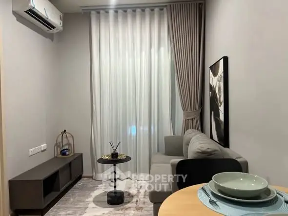 Modern living room with cozy sofa, elegant curtains, and stylish decor in a compact apartment setting.