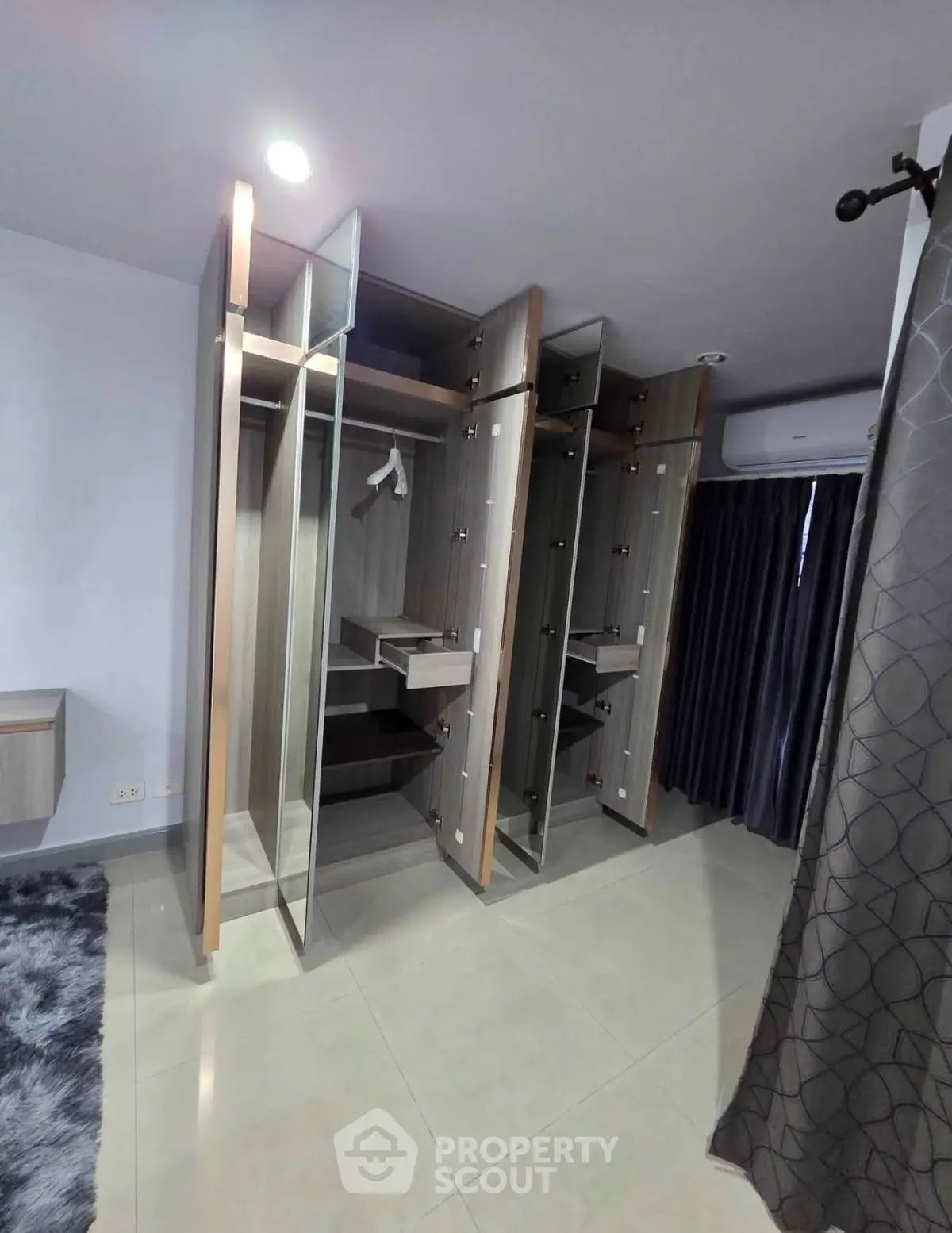 Spacious modern wardrobe with glass doors in a stylish bedroom setting.